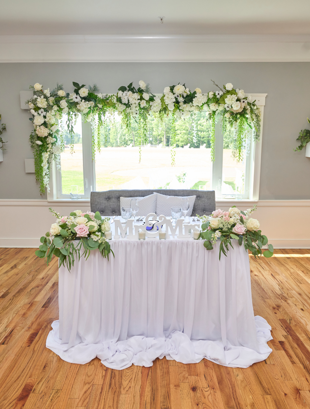 Elegant sweetheart table decorated with florals inside The Oaks Grandview Venue, styled for a small, intimate micro wedding reception.