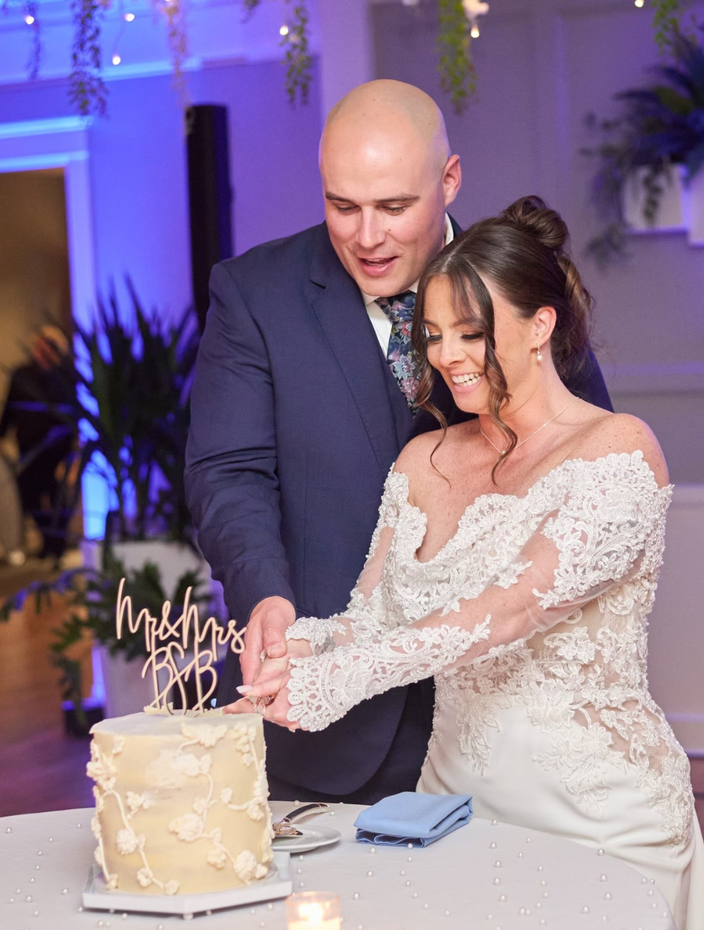 Bride and groom cutting a wedding cake during an intimate indoor reception at The Oaks Grandview Venue, showcasing a romantic micro wedding celebration.