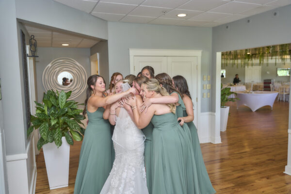 Bridal party embracing the bride in the bridal suite at The Grandview