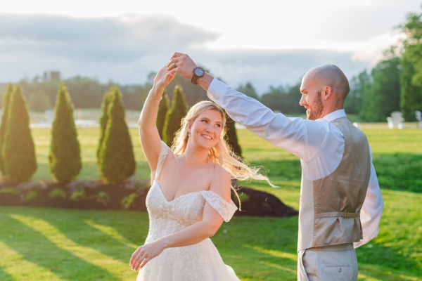 Couple twirling against the light of golden hour outside at The Grandview
