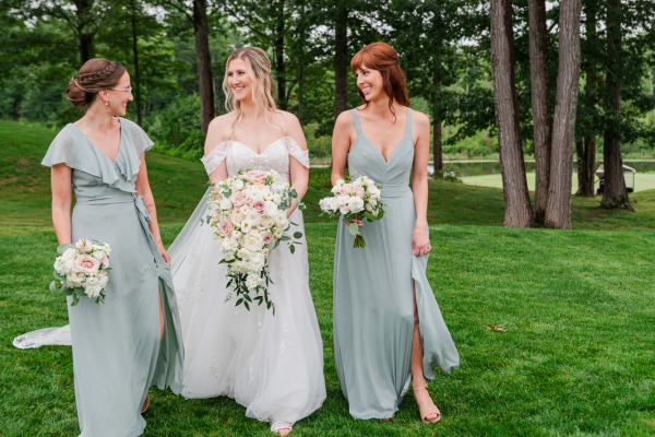 Bride and bridesmaids walking on reception lawn
