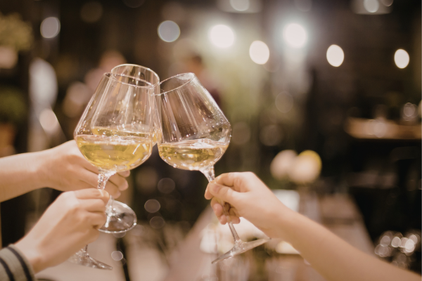 people cheersing wine glasses at a social event